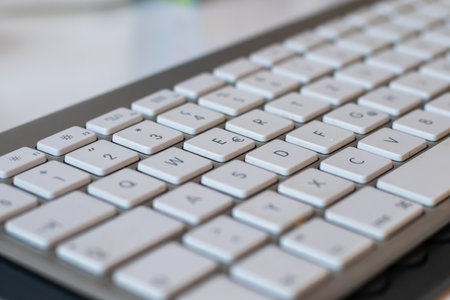 Close-up of a white computer keyboard in background.