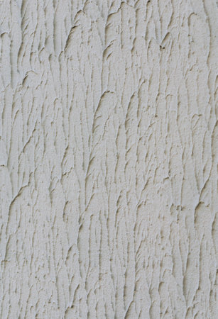 Background of gray one-color facade plaster. Single-layer cement monolithic plaster for decorative background. Exterior of the building facade covered with decorative textured plasterの写真素材