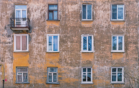 Windows on the facade of the old building. the walls of the building with peeling plasterの写真素材