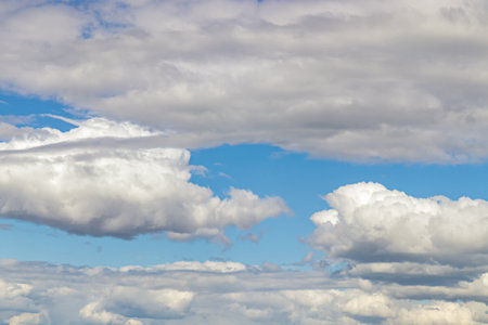 A few light Cumulus and Cirrus clouds in a clear blue sky, summer bright image of the sky.