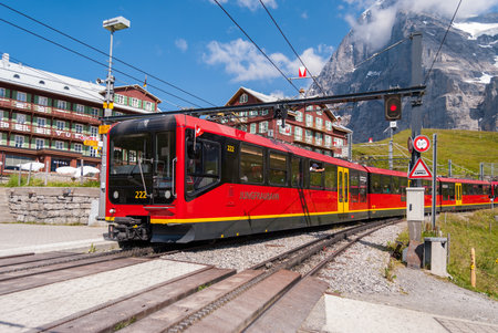 red electric tourist train goes from the station Jungfraujoch top of Europe Kleine Scheidegg Bernese...