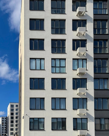 Facade of a new apartment building with modern design on a clear day, copy space