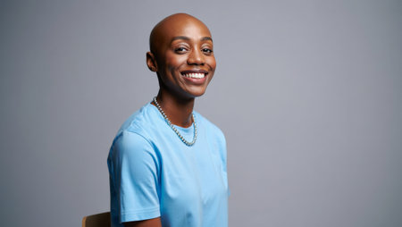 Smiling person in blue shirt against gray background. generated by aiの素材