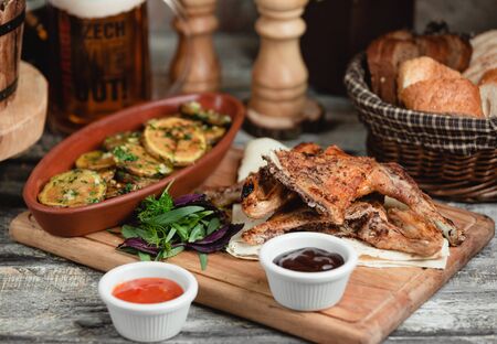 chicken legs with potatoes on a wooden standの写真素材