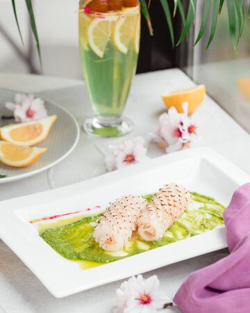Fish roulets in sauce on the tableの写真素材
