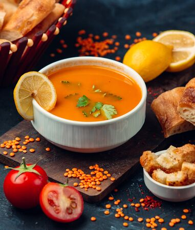 Red lentil soup with a slice of lemon and breadcrumbsの写真素材