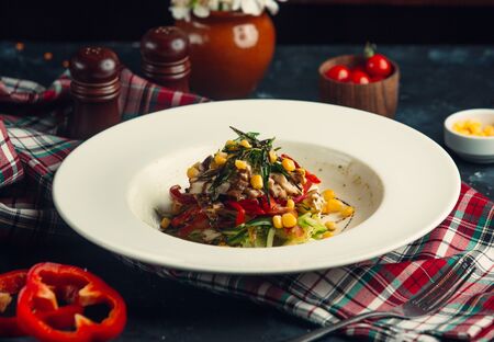 Layered salad with lettuce, cucumber, bell pepper, corn, turkeyの写真素材