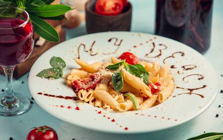 Penne pasta with tomatos, parmesan chees on topの写真素材