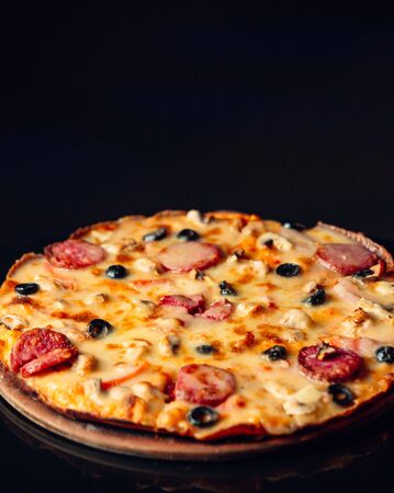 Pepperoni pizza with pepperoni, olive cheese in black backgroundの写真素材