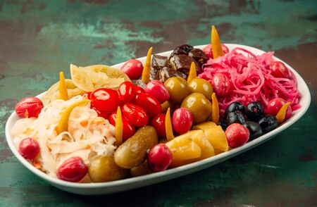 A plate of pickled vegetables aubergine, cucumber, red and white cabbage, oliveの写真素材