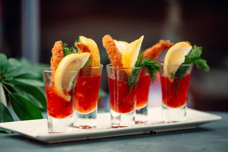 Delightful chicken croquettes in sweet chili sauce shots with lemon slicesの写真素材