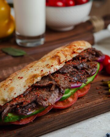 Meat slices in bread with cucumber and tomatoの写真素材