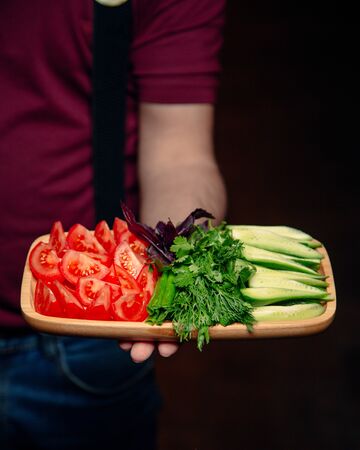 Sliced tomato and cucumber with greeneryの写真素材