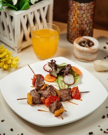 Meat pieces with vegetables grilled on stickの写真素材