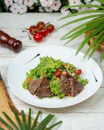 Meat slices with vegetables topped with sesameの写真素材
