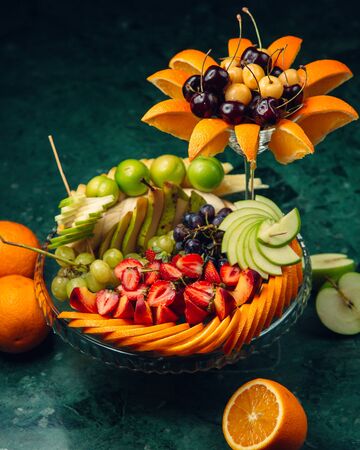 Decorated fruit plate with sliced fruitsの写真素材