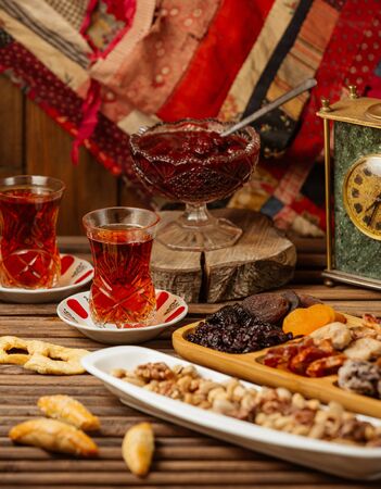 azerbaijani tea setup with tea in armudu glass, dried fruits and nutsの写真素材