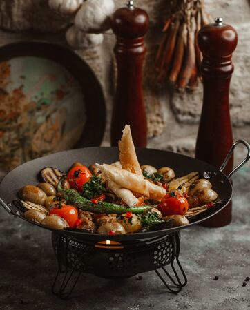 azerbaijani chicken saj with tomato, potato, pepper, aubergine and flatbread wrapsの写真素材