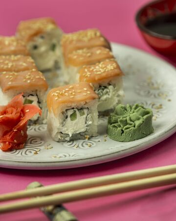 close up of sushi rolls covered with salmon served with wasabi, gingerの写真素材