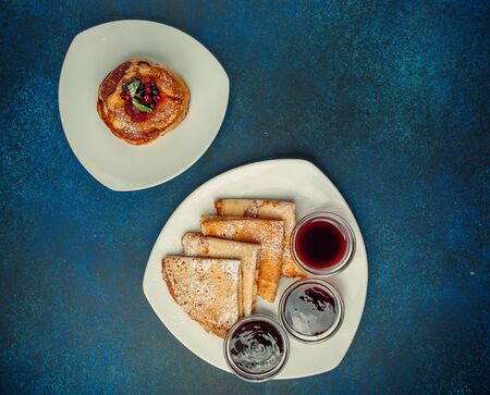 top view of pancakes and crepes with berries and jamsの写真素材