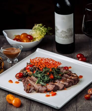 lamb kebab slices with aubergine salad garnished with spinachの写真素材