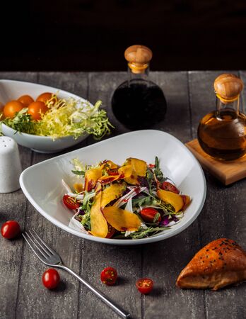a bowl of gresh vegetable salad served with pomegranate sauce and oilの写真素材
