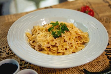 close up of farfalle with mushroom and chicken garnished with parmesa and parsleyの写真素材