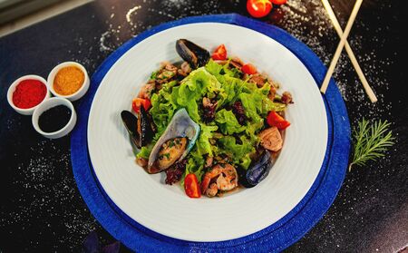top view of seafood salad with fresh lettuce, tomato, fried shrimp and musselsの写真素材