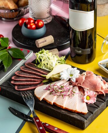 meat plate garnished with flowers, pear and arugulaの写真素材
