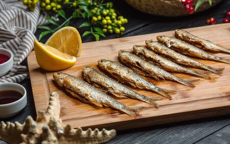 fried fishes set on wooden boardの写真素材