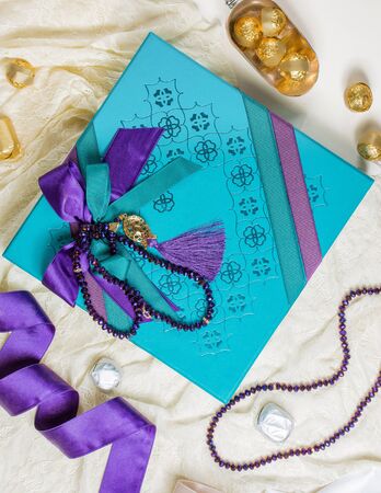 top view of turqouise chocolate box decorated with purple ribbonの写真素材