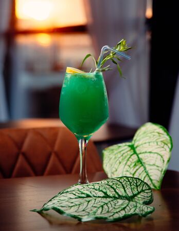 green cocktail with ice on the tableの写真素材