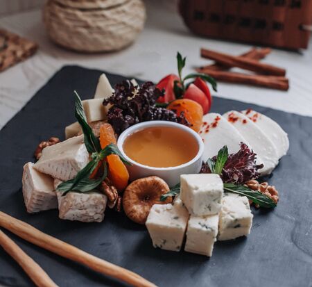 cheese plate with honey on the tableの写真素材