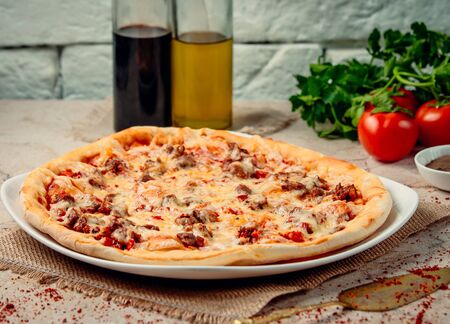 pizza with fried meat on the tableの写真素材