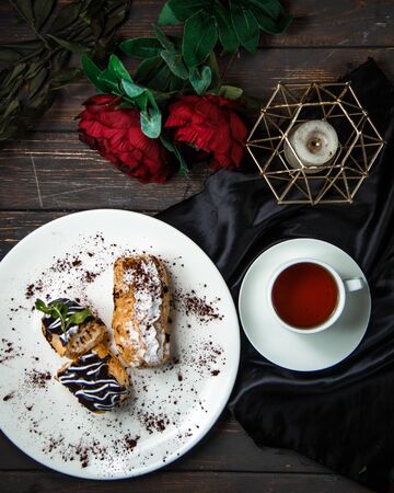 sweet eclairs with black tea top view