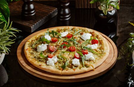 pesto pizza with cherry tomatoes, mozarella and arugulaの写真素材