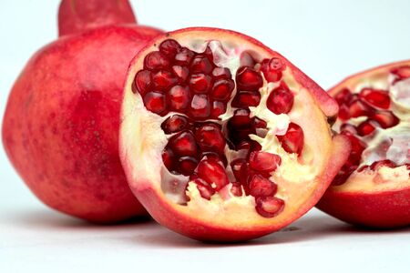 close up of half-divided pomegranates in white backgroundの写真素材