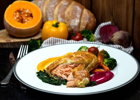salmon pie served with roasted herbs, vegetables and sour sauceの写真素材