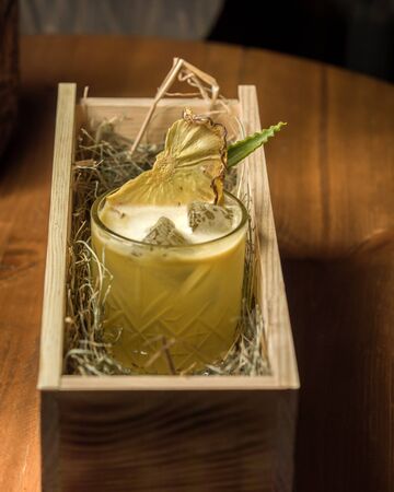 pineapple cocktail with ice and dried pineapple serve in woodの写真素材