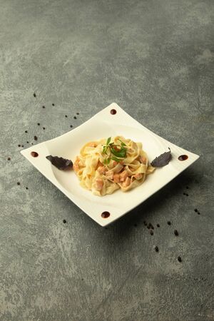a plate of fettuccini with chicken in plain grey backgroundの写真素材