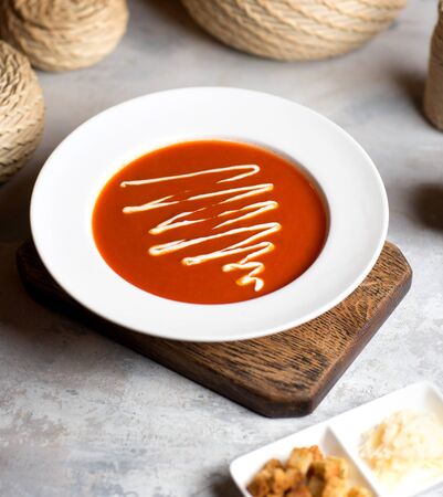 tomato soup with sauce on the tableの写真素材