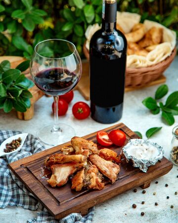 fried chicken on wooden board with red wineの写真素材