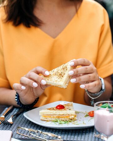 woman holding sandwich in handsの写真素材