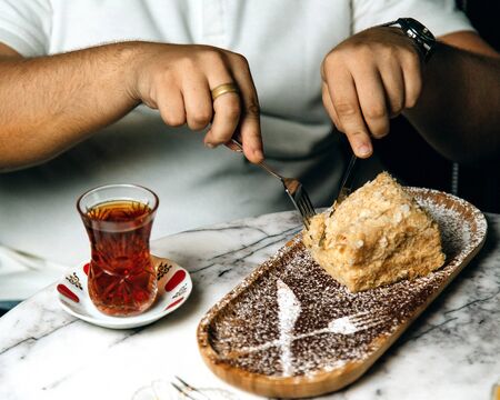 man eating a cake with teaの写真素材