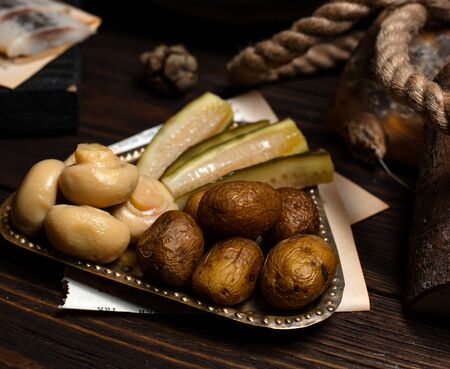 silver plate of pickled mushrooms, cucumbers and baked potatoesの写真素材