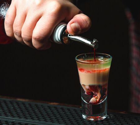 multicolor cocktail in shot on the table