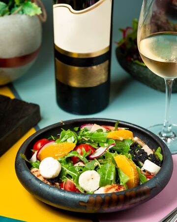 chicken salad with tomato radish and orange slicesの写真素材