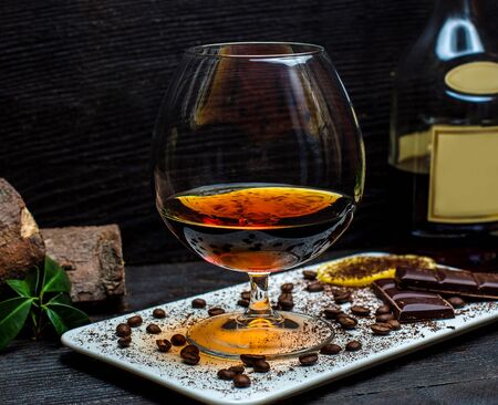 glass of cognac and chocolate barsの写真素材