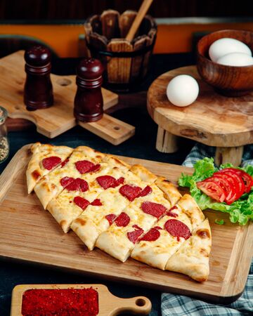 turkish pide garnished with cheese and pepperoniの写真素材