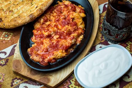 cast iron platter of egg and tomato dish served with